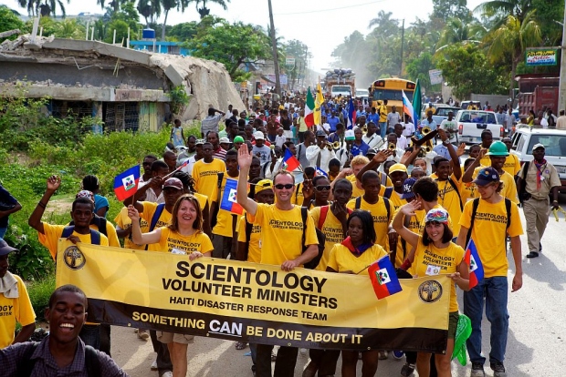Ministros Voluntários de Scientology de Haiti e de outras nações marcham desde Carrefour, um subúrbio de Port–au–Prince, para a cidade de Léogane em comemoração do Dia da Bandeira, um feriado nacional que comemora a independência do Haiti da opressão e escravidão francesa em 1803.